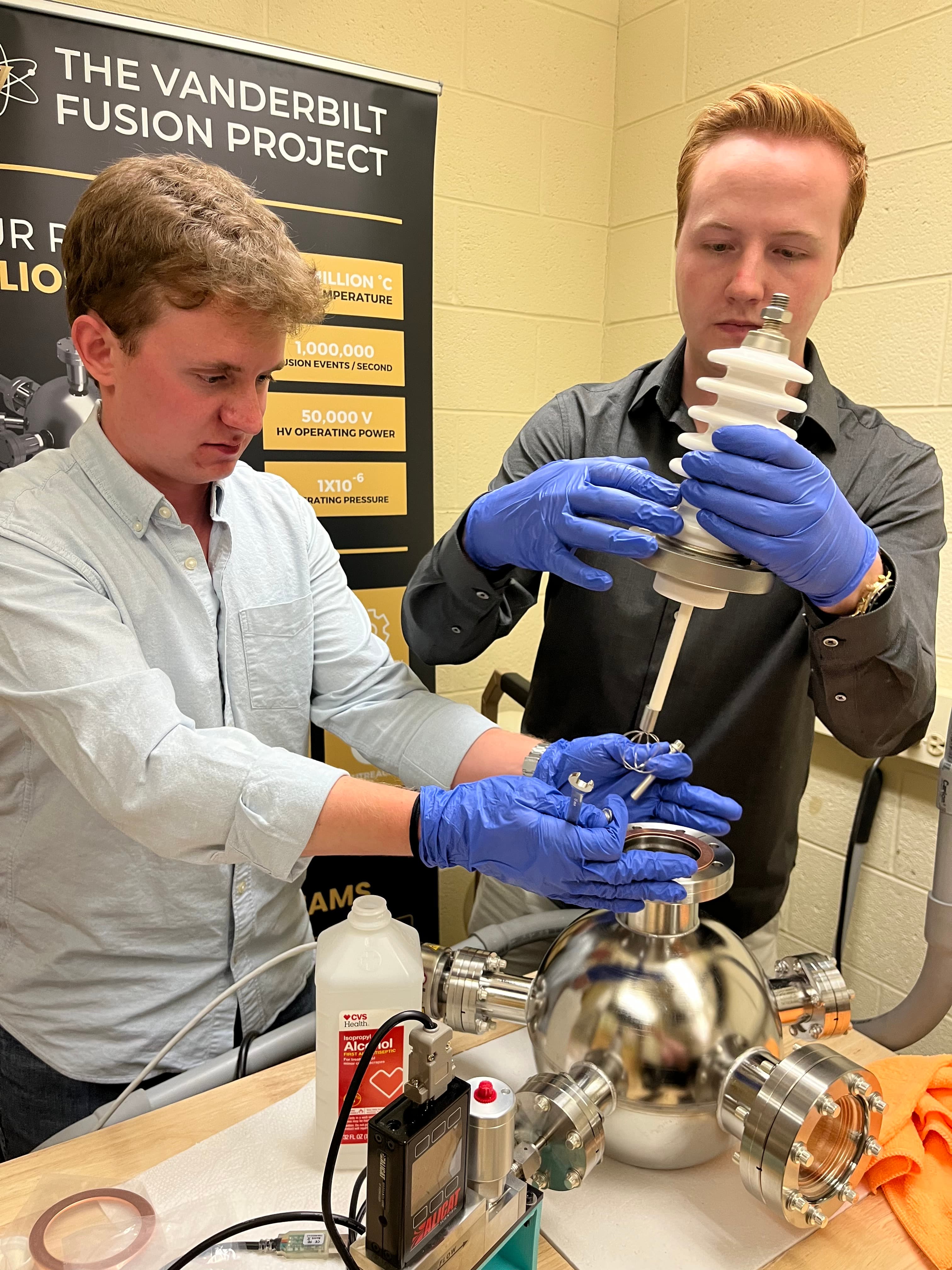 Two team members installing the high-voltage feedthrough on HELIOS Mk. 1